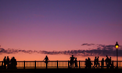 Silhouette people against scenic sky