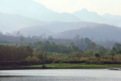 Scenic view of lake by trees against sky