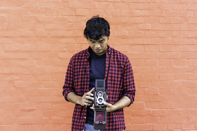 Man photographing against wall