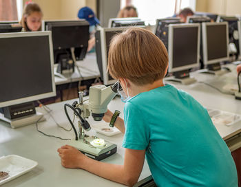 Boy examines the preparations under the microscope. classroom activities. practical lesson.