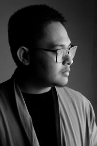 Portrait of young man against black background