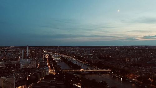 High angle view of illuminated cityscape against sky at dusk