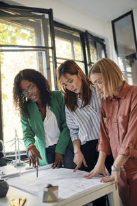 Businesswomen having a meeting in office with wind turbine models on table