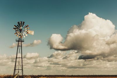 Low angle view of windmill against blue sky