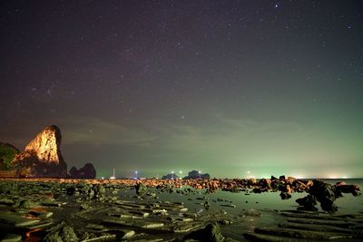 Scenic view of beach against star field in sky during night