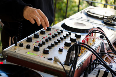 Midsection of dj playing music outdoors