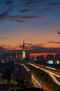 Illuminated buildings in city at sunset