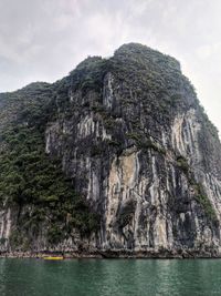 Rock formations by sea against sky