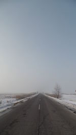 Road against clear sky during winter