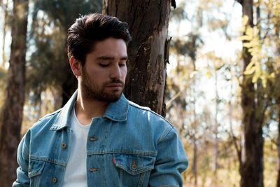 Thoughtful man looking away in forest