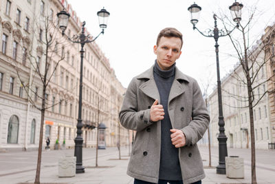 Young man walking down street, autumn or winter cold day. outdoors, outside.