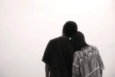 Rear view of couple standing against clear sky