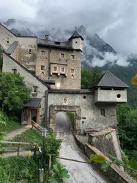 Houses by mountain against sky