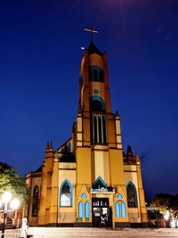 Low angle view of illuminated building against sky at night