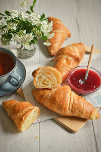 Closeup table with fresh baked croissant and tea
