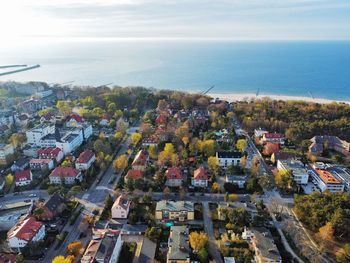 High angle view of townscape by sea against sky