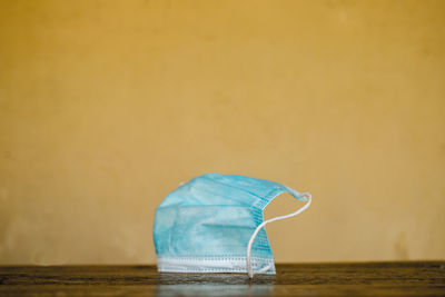 Close-up of blue umbrella on table against wall