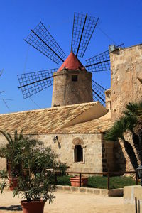 Low angle view of windmill against clear blue sky