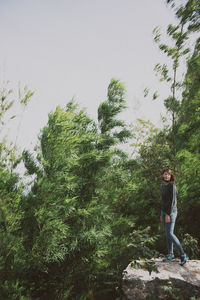 Man standing on rock against trees