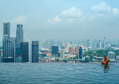 Sea by swimming pool against buildings in city