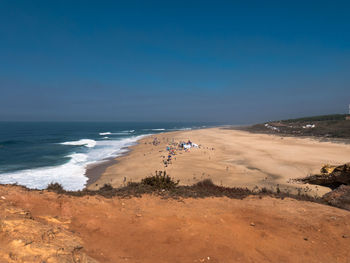 Scenic view of beach against clear blue sky