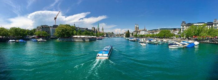 Boats moored in city against sky