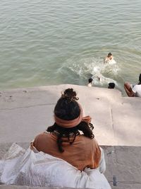 Rear view of people sitting on beach