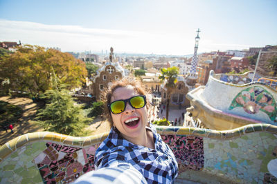 Portrait of smiling young woman against sky