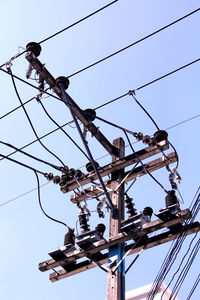 Low angle view of electricity pylon against clear sky