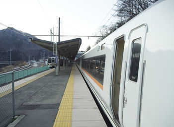 Train at railroad station platform against sky