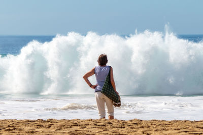 Rear view of woman looking at sea waves