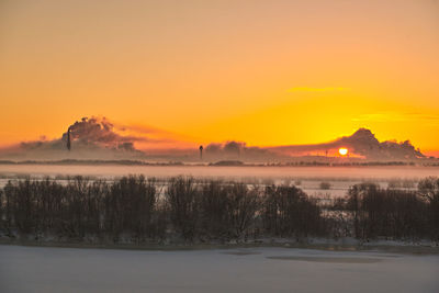 Scenic view of lake against orange sky during sunset