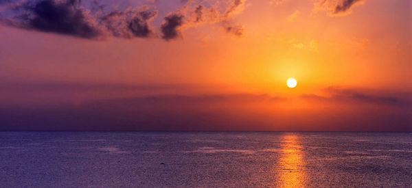 Scenic view of sea against romantic sky at sunset