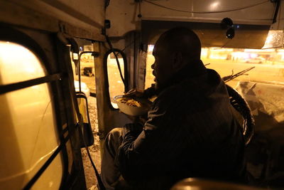 Rear view of man working in bus