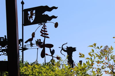 Low angle view of silhouette flowering plants against clear sky