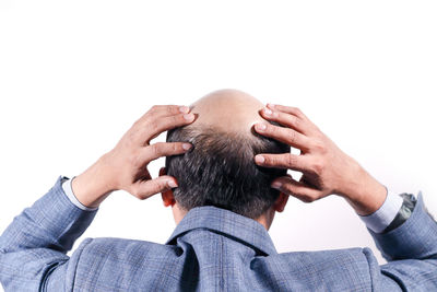 Close-up of man with hands over white background