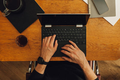 High angle view of man using laptop on table