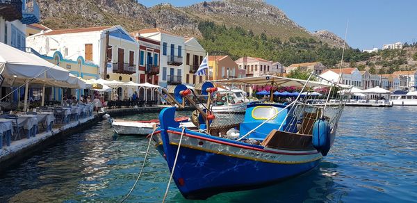 Boats moored in sea by buildings in city