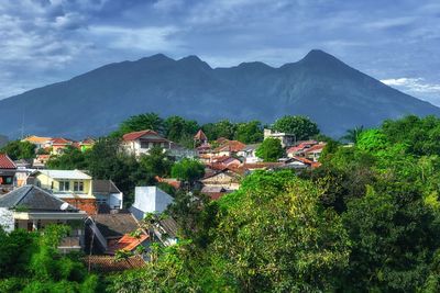 Houses and trees against mountains