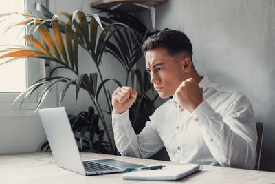 Young man using laptop at office