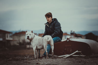 Man and dog on field against sky