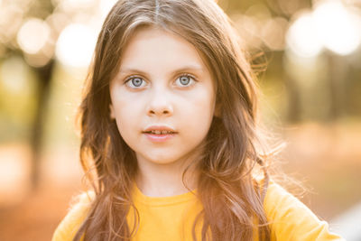 Beautiful cute child girl 5-6 year oldwith long blonde hair outdoor over nature autumn background.