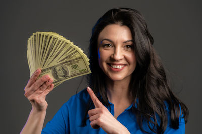 Portrait of a smiling young woman against blue background