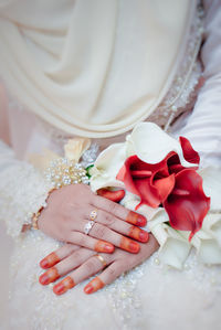 Close-up of bride holding bouquet of rose