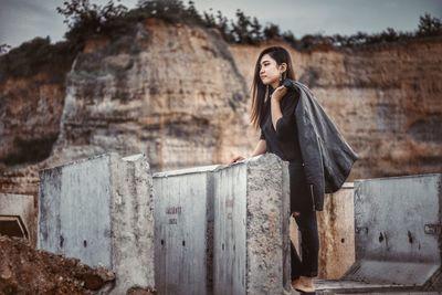 Side view of woman standing against wall