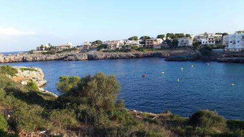 Scenic view of sea by buildings against sky