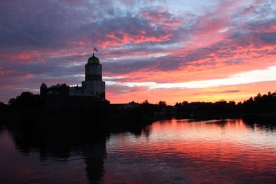 Scenic view of river against cloudy sky at dusk