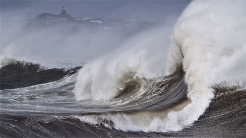 Close-up of waves splashing in sea against sky