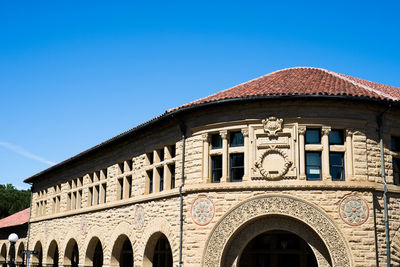 Low angle view of historical building against clear blue sky