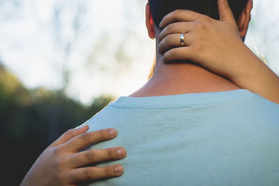 Cropped hands of woman embracing man